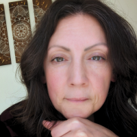 woman with brown hair resting face on hand